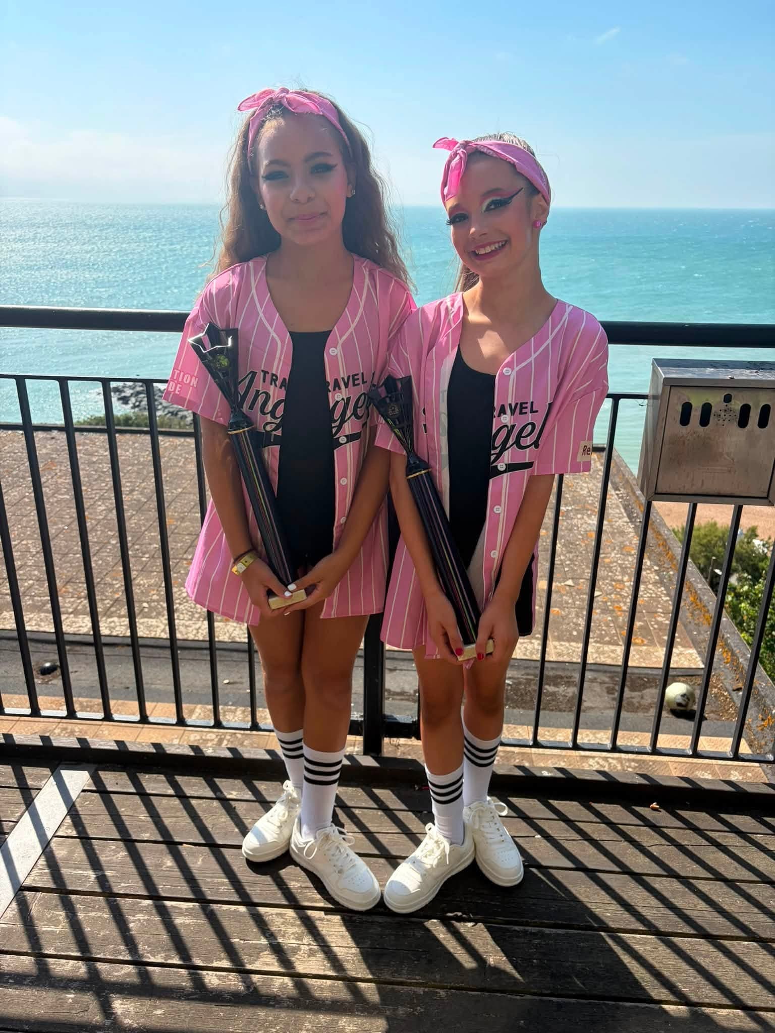 Duo in pink and white jerseys with trophies