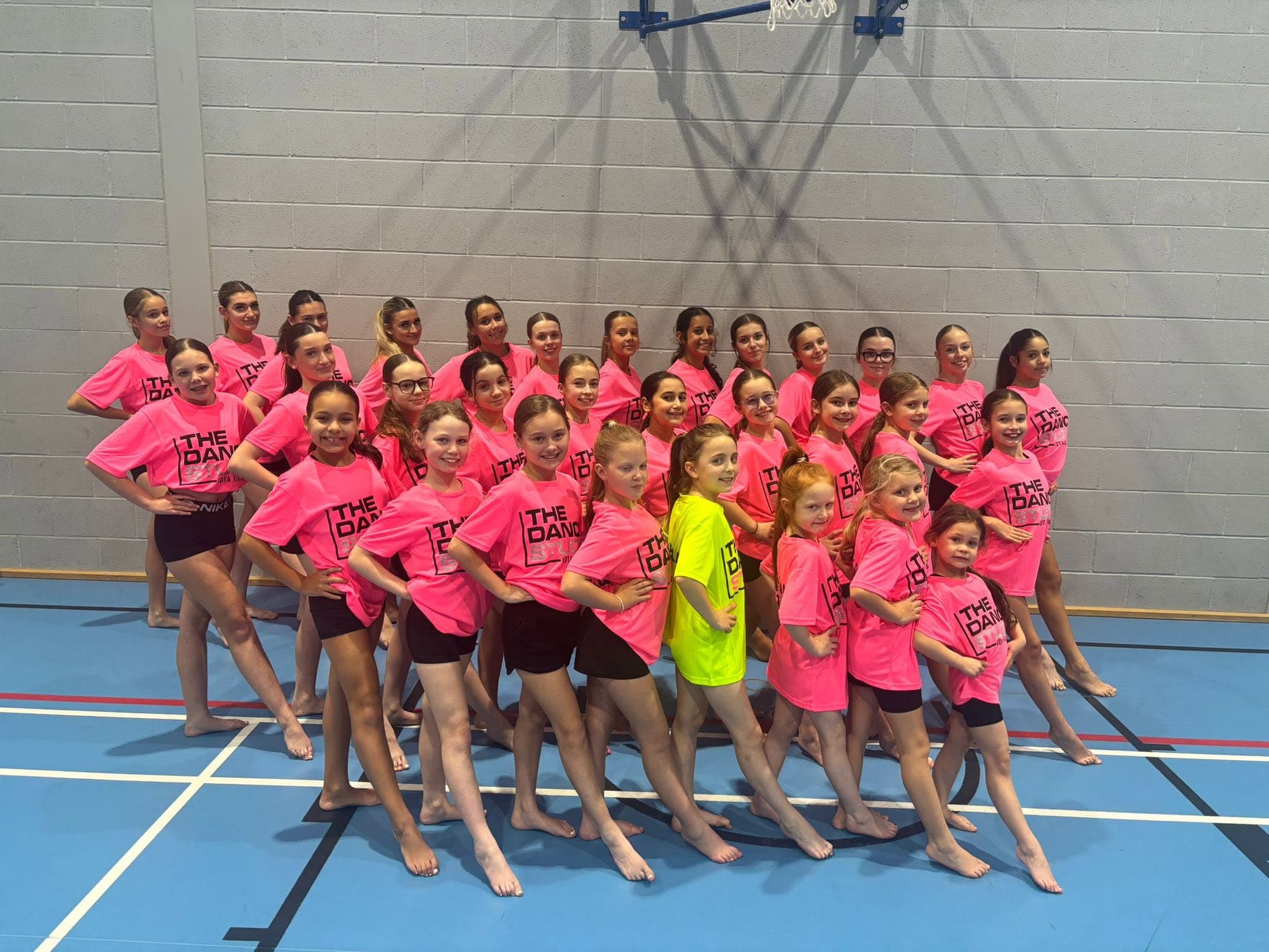 The Dance Studio group in neon pink merch
